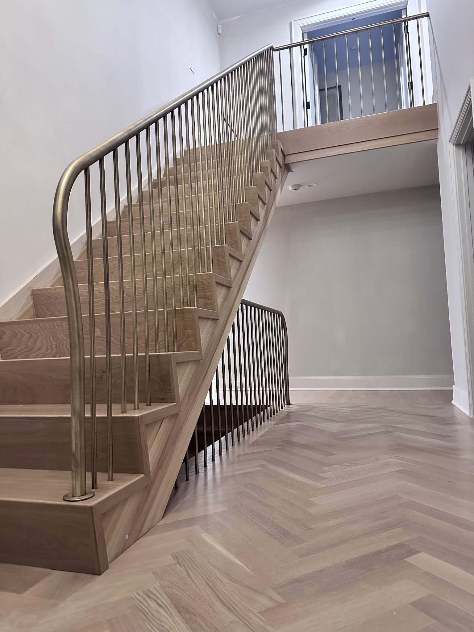 Curved staircase railing with custom metalwork in Fairfield County CT residential home